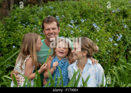 Famiglia di quattro tra piante verdi Foto Stock