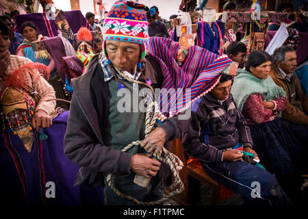 Gruppi di persone frequentano la Messa celebrata al mattino presto durante la celebrazione di Tinku. Foto Stock