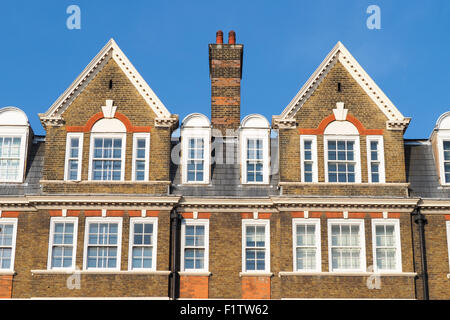 Facciata degli edifici a Londra con i tradizionali tetti e un camino Foto Stock