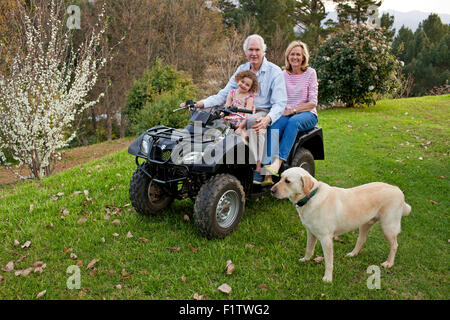 Nonno e la nonna e la nipote su quadbike e Labrador cane Foto Stock