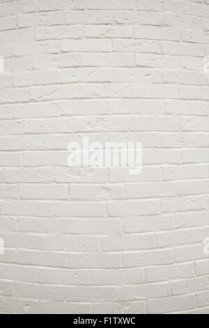Formato verticale di un dipinto di bianco di un muro di mattoni curvo in centro utilizzata come sfondo. Foto Stock