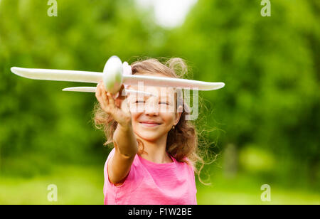 Happy girl close-up che detiene aeroplano giocattolo Foto Stock