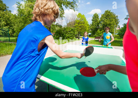 Quattro amici internazionali giocando a ping pong Foto Stock