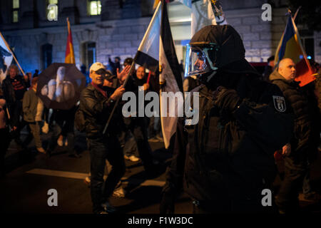 Berlino, Germania. Il 7 settembre, 2015. Un funzionario di polizia si affaccia su come anti immigrazione manifestanti passare il Bundesdag. Estrema destra gruppi e partiti politici NPD ha dimostrato oggi contro l'immigrazione a berlinese Brandenburger Tor, Berlino Germania Credito: Rey T. Byhre/Alamy Live News Foto Stock