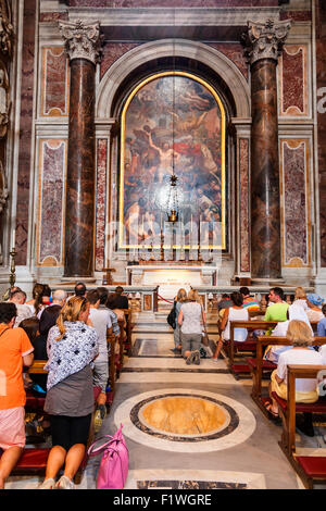 Persone in preghiera davanti alla tomba di Papa Giovanni Paolo II, Basilica di San Pietro e la Città del Vaticano, Roma, Italia. Foto Stock