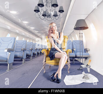 Bella donna in poltrona di lusso in la cabina di un aeromobile. 3d il concetto di creatività Foto Stock