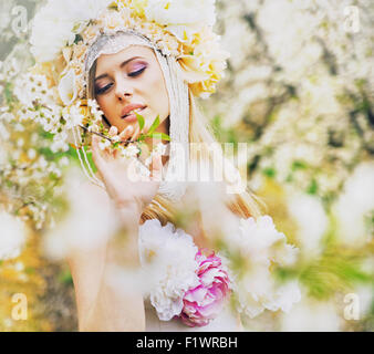 Giovane donna bionda nel profumato giardino di primavera Foto Stock