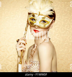 Bella giovane donna nel misterioso golden maschera veneziana. Fotografia di moda Foto Stock