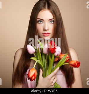 Ritratto di bella dai capelli scuri Donna con fiori. Fotografia di moda Foto Stock