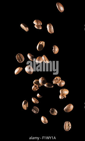 La caduta di chicchi di caffè su sfondo nero. Foto Stock