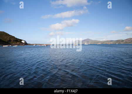 Una vista in tutta l'acqua a Porth Dinllaen, Morfa Nefyn attraverso Yr Eifl alla fine di una giornata estiva con barche ancorate nella baia Foto Stock