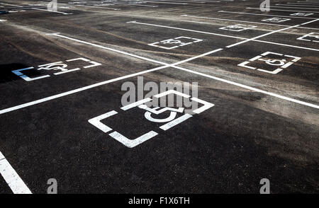 I posti di parcheggio con portatori di handicap o disabilitato segni e linee di marcatura su asfalto Foto Stock