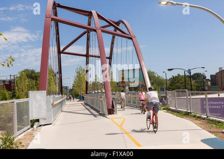 I ciclisti a Milwaukee Avenue ponte sul 606 elevata bike trail, spazi verdi e parco costruito sul vecchio Bloomingdale Linea nella Logan Square quartiere di Chicago, Illinois, Stati Uniti d'America Foto Stock