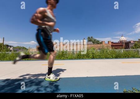 Un runner del 606 elevata bike trail, spazi verdi e parco costruito sul vecchio Bloomingdale Linea nella Logan Square quartiere di Chicago, Illinois, Stati Uniti d'America Foto Stock
