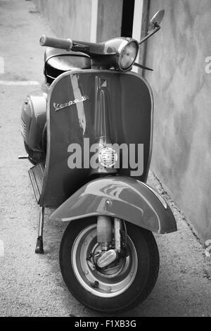Gaeta, Italia - 19 agosto 2015: Classic scooter Vespa parcheggiata sorge in prossimità della parete verticale della foto Foto Stock