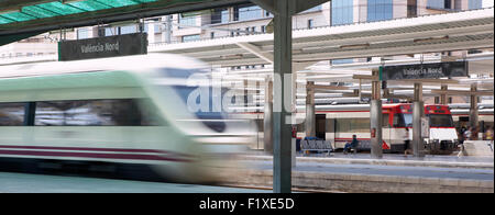 Stazione ferroviaria e piattaforma con la segnaletica orizzontale e di un treno ad alta velocità Foto Stock