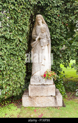 La statua della Madonna nel parco di Buckfast Abbey, Devon UK, tenendo il Bambino Gesù bambino. Foto Stock