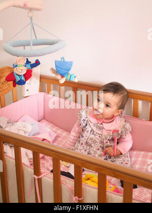 Baby girl all'interno della culla Foto Stock