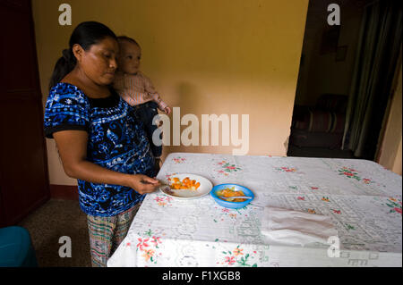 Guatemala, Salama, madre preparare il cibo per il bambino (Maria Domitilla Ximutul Tista 35, Rodolfo Anibal Monzon Tejeda10 meses) Foto Stock