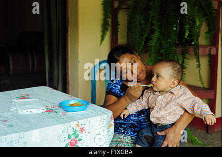 Guatemala, Salama, madre preparare il cibo per il bambino (Maria Domitilla Ximutul Tista 35, Rodolfo Anibal Monzon Tejeda10 meses) Foto Stock