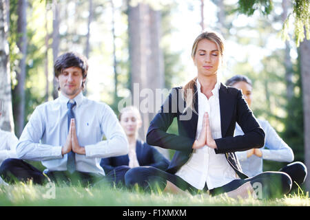 La gente di affari fare yoga Foto Stock