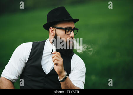 Con barba fuma sigaretta elettronica Foto Stock