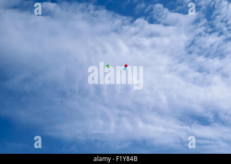 Tre multi-di palloncini colorati volare (hover) nel cielo blu con nuvole Foto Stock