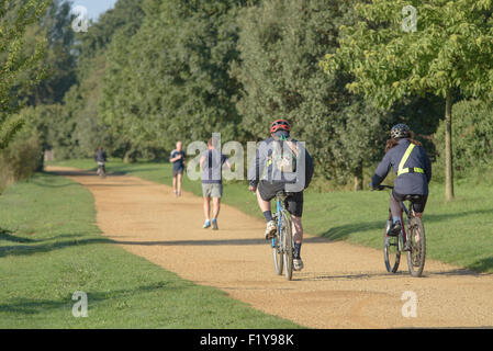 Persone in bicicletta e fare jogging lungo una strada alzaia in Londra Foto Stock