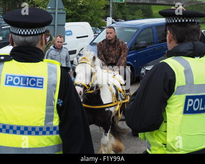 Due poliziotti guardare l uomo a cavallo disegnato trappola a famosi viaggiatori annuale raduno a Appleby Horse Fair, Cumbria Inghilterra England Regno Unito Foto Stock
