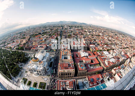 Palacio de Bellas Artes Aerial città del Messico | CITTÀ DEL MESSICO, Messico - Una vista aerea fisheye dalla Torre Latinoamericana si affaccia a nord sul Palacio de Bellas Artes, la sua cupola dorata in Art Nouveau e la facciata in marmo di Carrara che fissa il Centro Histórico. Costruito tra il 1904 e il 1934, il palazzo affondò di circa 4,3 m nei morbidi sedimenti di lago dell'antica Tenochtitlan durante la costruzione, lo stesso terreno instabile che continua a spostare edifici attraverso il centro storico. Foto Stock