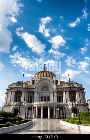 Palacio de Bellas Artes Facciata completa Città del Messico Estate | CITTÀ DEL MESSICO, Messico — Il Palacio de Bellas Artes si erge sopra i suoi giardini Alameda, la sua facciata in marmo bianco di Adamo Boari e la corona in bronzo di Géza Maróti si staglia contro il cupolone. La costruzione iniziò nel 1904 e si fermò per 16 anni dopo la Rivoluzione e problemi di subsidenza, prima che Federico Mariscal completasse l'interno in stile Art Déco e l'edificio aprisse nel 1934. Foto Stock