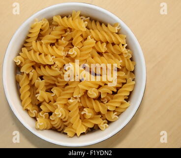 Ciotola di Fusilli su uno sfondo di legno, copia dello spazio. Foto Stock