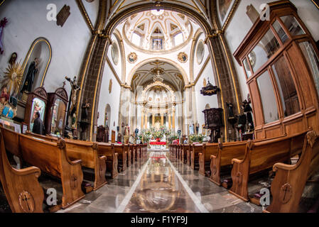 CITTÀ DEL MESSICO, Messico — la navata principale dell'Iglesia de San Bernardo si estende verso il suo ornato altare barocco. Questa chiesa coloniale del XVII secolo, situata vicino allo Zocalo di città del Messico, presenta elementi architettonici tradizionali cattolici. L'interno della chiesa mostra elementi caratteristici del design barocco messicano. Originariamente parte di un complesso convento, la chiesa rimane una testimonianza dell'architettura religiosa coloniale dopo la chiusura del convento nel XIX secolo. Foto Stock