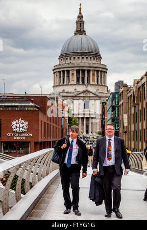 Due uomini di affari in giacca attraversare la passerella del Millennio, Londra, Inghilterra Foto Stock