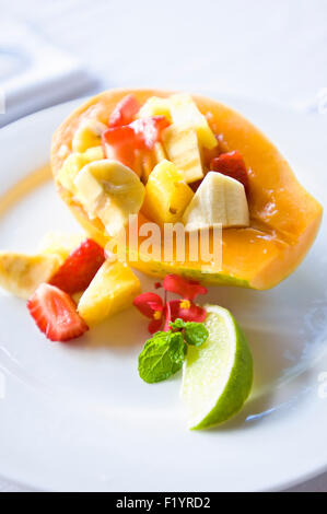 La colazione insalata di frutta su una chiara piastra bianca su una tovaglia bianca Foto Stock
