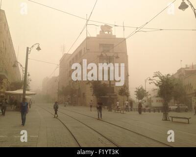 Gerusalemme, Israele. 8 Settembre, 2015. Gli israeliani a piedi attraverso il light rail tracce su Jaffa Road di Gerusalemme come la tempesta di sabbia si deposita sulla città il 08 settembre 2015. In caso di grave tempesta di polvere è arrivato martedì in Israele, che copre il paese in una pesante haze.La tempesta di sabbia spazzata anche in altre parti del Medio Oriente. Credito: Eddie Gerald/Alamy Live News Foto Stock