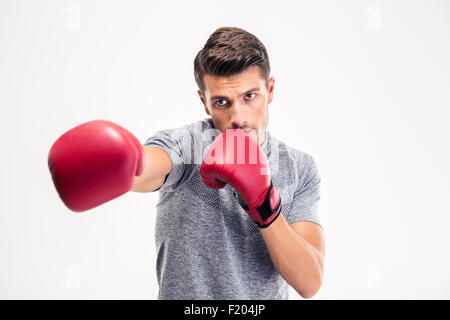 Ritratto di un giovane uomo che colpisce in telecamera nella boxe guanti isolati su sfondo bianco Foto Stock