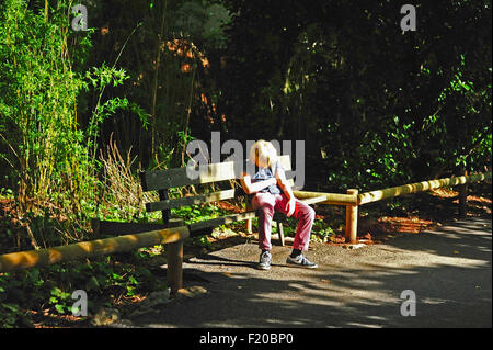 Sleeping ragazzo su una panchina nel parco Foto Stock