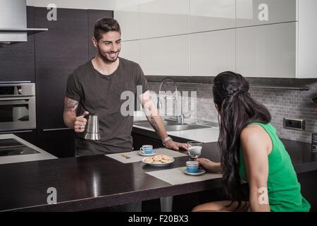 Giovane uomo versando la colazione al caffè per ragazza Foto Stock