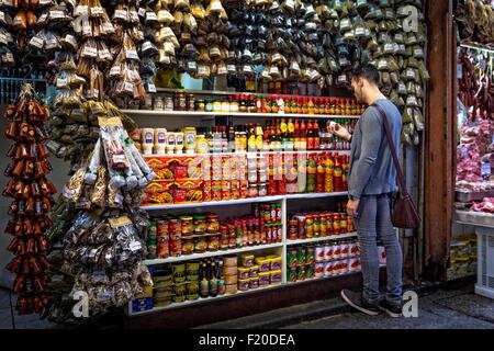 Giovane uomo selezionando le spezie in stallo del mercato, Sao Paulo, Brasile Foto Stock