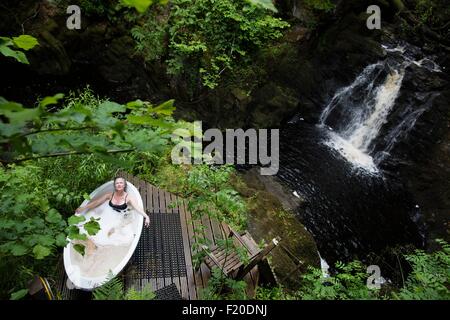 Elevato angolo di visione della donna matura in bagno di bolle di fronte a cascata rifugio eco Foto Stock