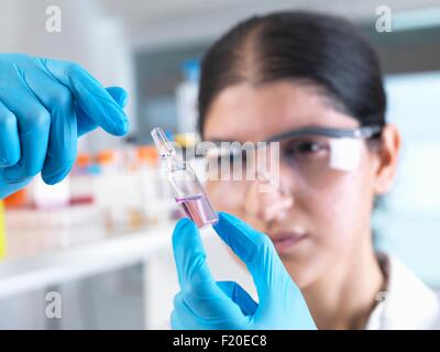 Donna scienziato sperimentazione medica fiala di farmaco in laboratorio Foto Stock