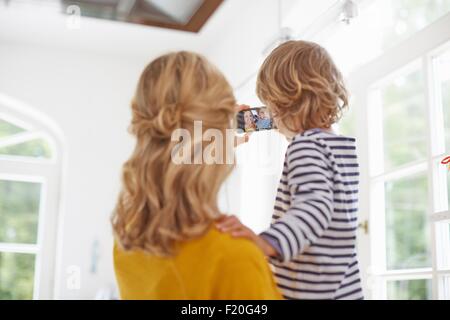 Madre e figlio tenendo selfie in cucina Foto Stock