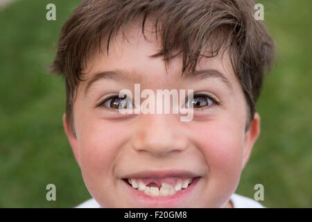 Ritratto di giovane ragazzo che sorride, mostrando di gap dal dente perduto Foto Stock