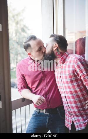 Coppia gay kissing dalla finestra Foto Stock