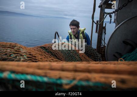 Fisherman preparazione net, Isola di Skye in Scozia Foto Stock