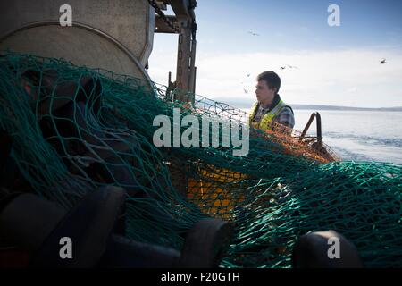 Fisherman preparazione net, Isola di Skye in Scozia Foto Stock