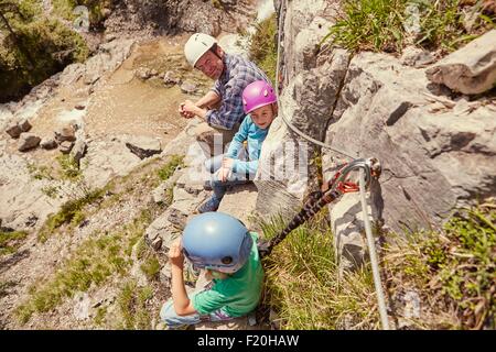 Padre e figli godendo di vista sulle rocce, Ehrwald, Tirolo, Austria Foto Stock