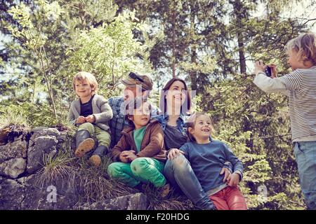 Ragazzo giovane tenendo fotografia di famiglia, nella foresta Foto Stock