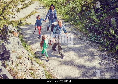 Famiglia camminare attraverso la foresta, tenendo le mani, vista in elevazione Foto Stock